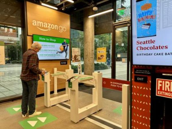 An Amazon Go customer pays with the store's mobile app at the self-service checkout counter.