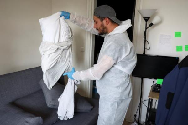 Salim Dahou, biocide technician from the Hygiene Premium company, removes pillowcases to prevent the spread of bedbugs in an apartment in L'Hay-les-Roses, near Paris, France, September 29, 2023. REUTERS/Stephanie Lecocq