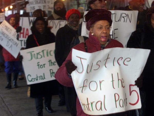 Demo<em></em>nstrators carry signs outside a New York City Court calling for justice in the case of five youths co<em></em>nvicted in the 1989 case of sexually assaulting a female jogger in New York's Central Park December 5, 2002.