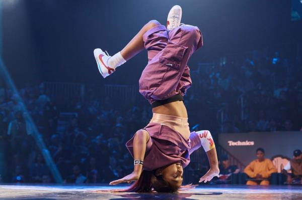 Logan Edra, known as B-Girl Logistx, performing a handstand on stage during the Red Bull BC One World Final