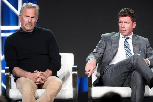 Kevin Costner sitting next to Taylor Sheridan. 