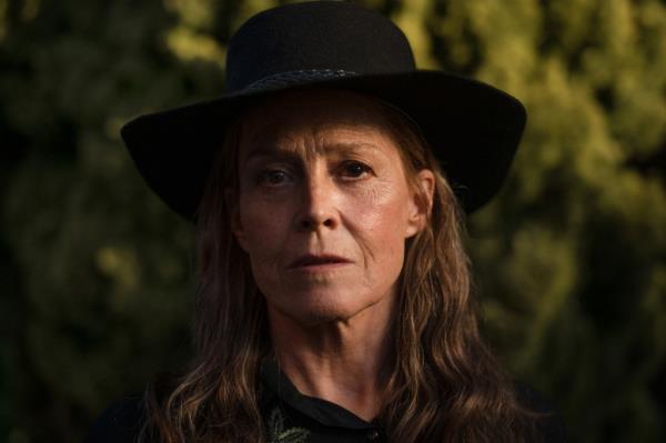 Sigourney Weaver looking grim wearing a hat. 