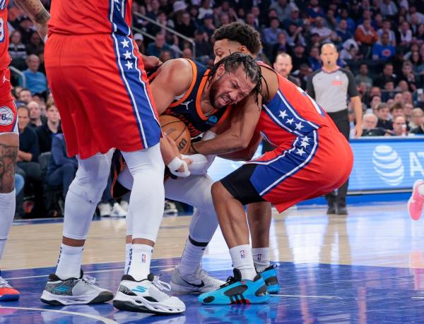 76ers Joel Embiid watches as Knicks guard Jalen Brunson fights with the 76ers Kyle Lowry for co<em></em>ntrol of the ball during the first quarter of Game 2.