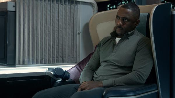 Idris Elba sitting on a plane. 