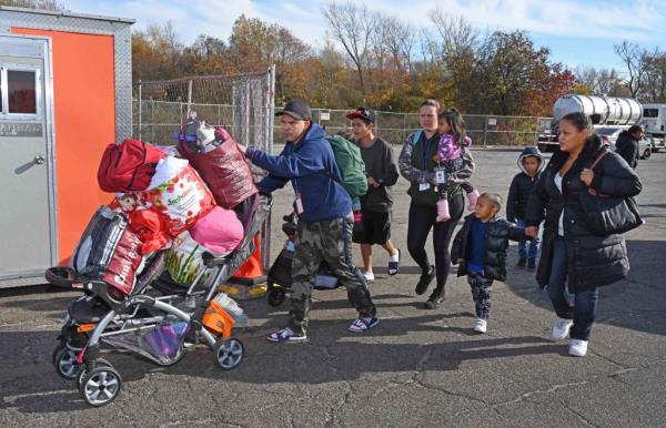 Migrants getting on a bus to leave after arriving at Floyd Bennett Field.