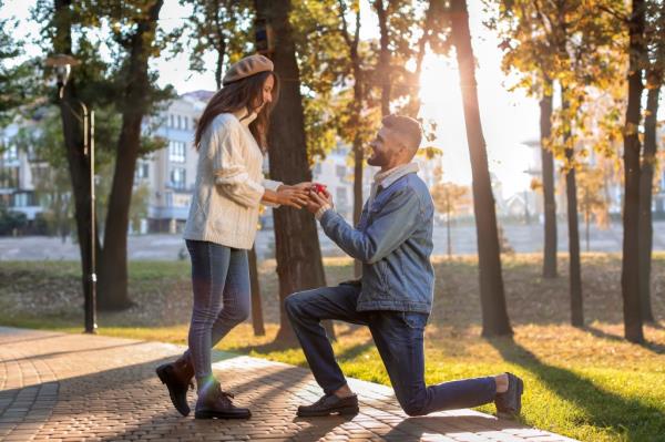 Young man proposing to his beloved in autumn park.