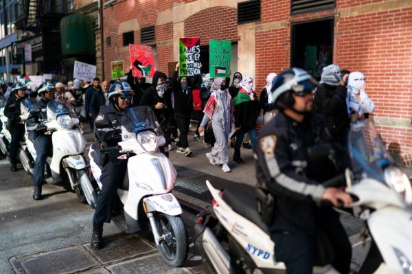 NYPD officers stand guard on scooters as people march after attending a demo<em></em>nstration to express solidarity with Palestinians