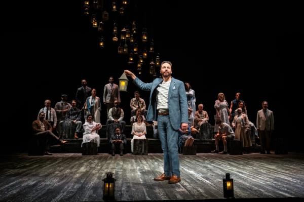 Jim Parsons holding a lantern onstage