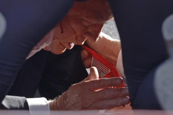 BUTLER, PENNSYLVANIA - JULY 13: Secret Service tend to republican presidential candidate former President Do<em></em>nald Trump o<em></em>nstage at a rally on July 13, 2024 in Butler, Pennsylvania. Butler County district attorney Richard Goldinger said the shooter is dead after injuring former U.S. President Do<em></em>nald Trump, killing one audience member and injuring another in the shooting. (Photo by Anna Moneymaker/Getty Images)