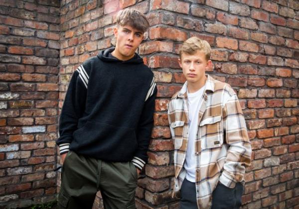 Mason and Dylan leaning against a wall in Coro<em></em>nation Street promo shot