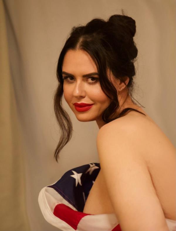 Courtney Casgraux poses holding American flag around her naked torso