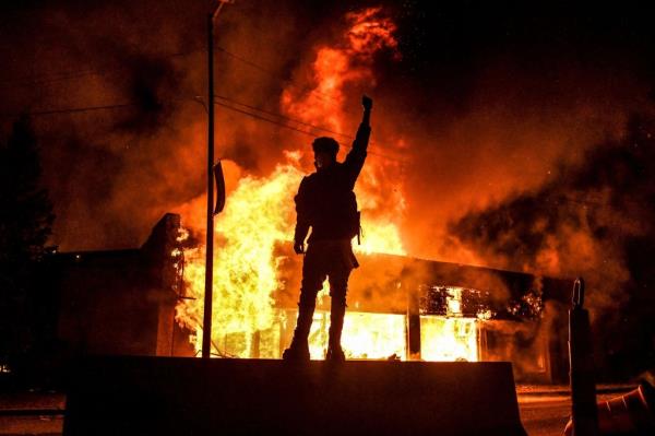 protestor, fire in background