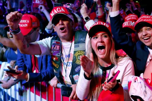 Supporters in red hats reacting to Fox News announcement of Do<em></em>nald Trump's election as president at event in West Palm Beach, Florida