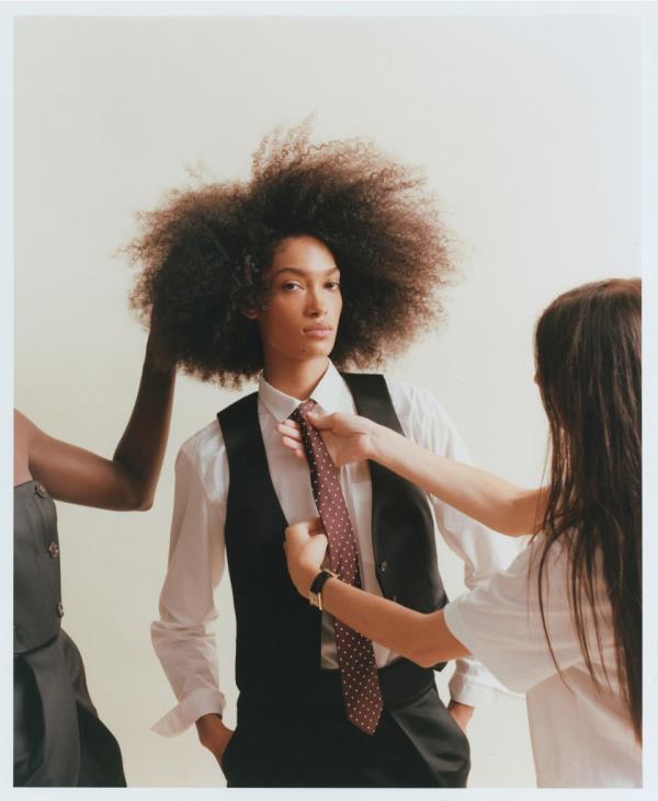 A woman fixing a tie from the new vibrant J.Crew collection by Christopher John Rogers