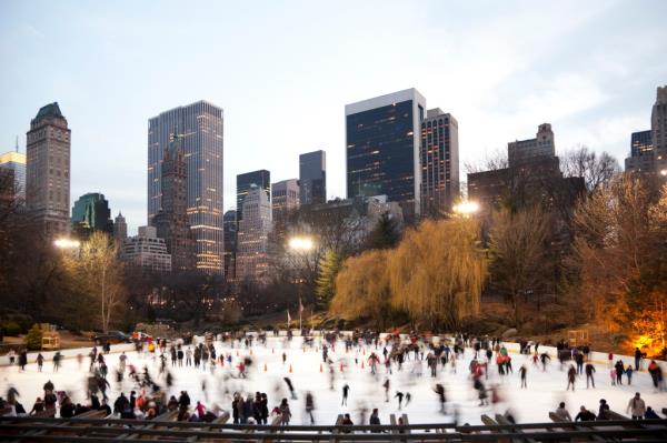 Group of people ice skating at Wollman Rink in Central Park during winter