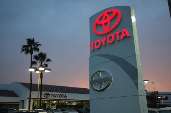 Toyota cars and trucks parked in a dealership lot, including Camry, Corolla, Matrix, Avalon, RAV4, Highlander, Tundra, and Sequoia models.