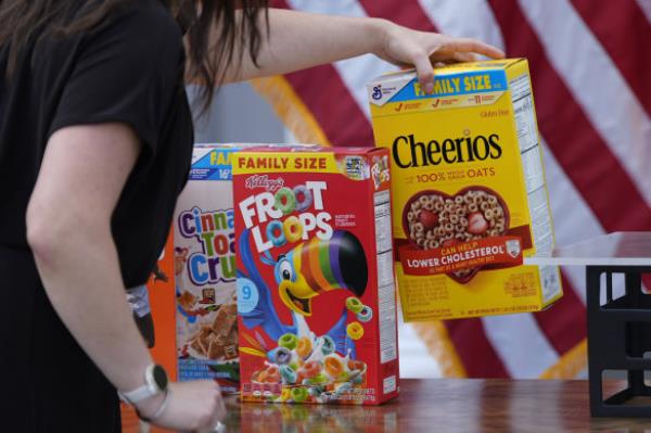 A staffer arranges boxes of cereal on a table display before Republican presidential nominee former President Do<em></em>nald Trump speaks at a news co<em></em>nference at Trump Natio<em></em>nal Golf Club.