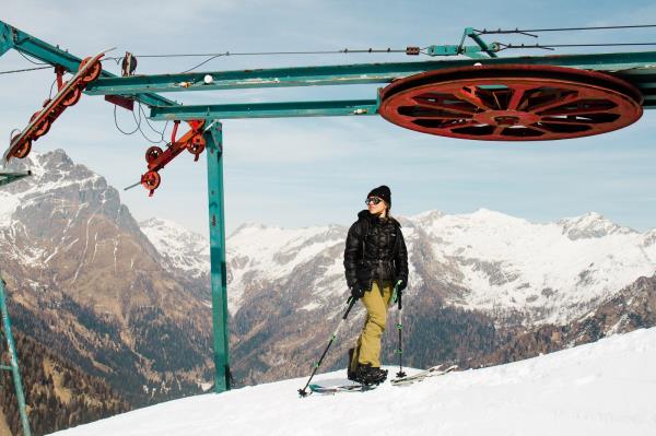 Person wearing skis standing on top of a snowy mountain