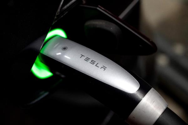Closeup of a charger plugged into a Tesla vehicle