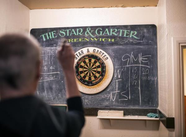 A man throws a dart at a dart board    