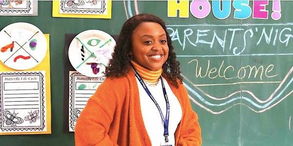Quinta Brunson's Janine smiles in front of a blackboard in Abbott Elementary
