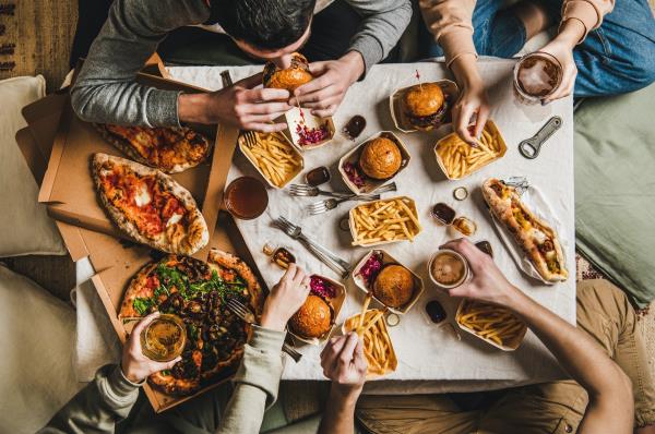 A birds eye view of people sitting around a table eating fast food.