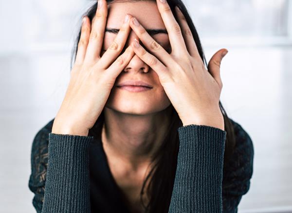 woman covering her eyes feeling stressed, co<em></em>ncept of ways to relieve stress in less than five minutes
