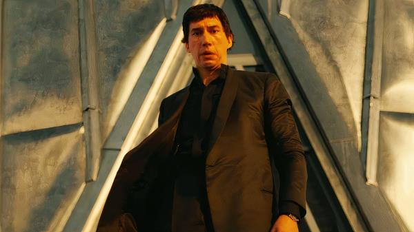 Adam Driver in Megalopolis standing at the top of a skyscraper looking down