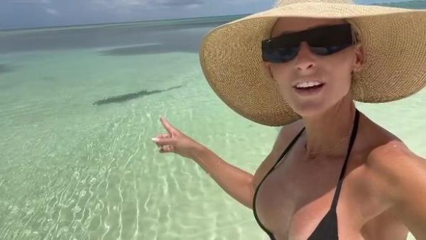 Michelle McCool pointing at a shark in the water